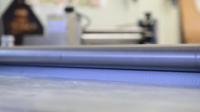 Rotating shafts of an industrial laminator in close-up in a printing house. Mechanics of rotation of metal shafts