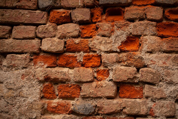 Obraz premium Close-up of a weathered red brick wall with visible mortar and aging textures in the historic Navigli district of Milan, Italy.