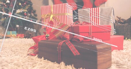 Displaying gifts resting on cream shag rug by lit conifer, with gold, tartan ribbons, jingle bell