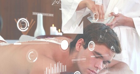 Client lying prone in spa with white towel, therapist in white robe prepping glass bowl, HUD