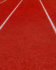 Fototapeta premium Running track surface with lanes marked for races at a sports facility during daylight hours