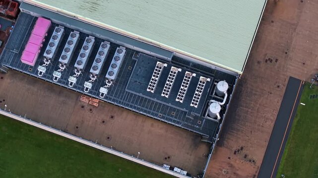 Aerial view of the Lloyds Horizon Data Centre, featuring rows of cooling units and storage tanks, contrasted by green fields, Corby, United Kingdom.