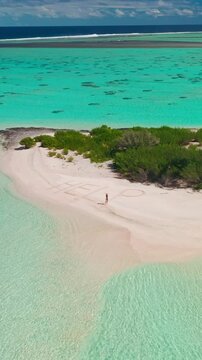 Woman writes help in the sand of a deserted tropical island in the maldives, surrounded by turquoise waters and lush greenery, creating a tranquil scene of solitude and hope