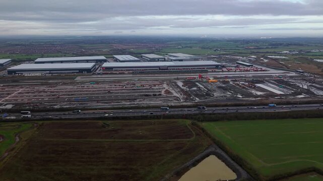 Northampton, United Kingdom - 17 January 2026: Aerial view of the Royal Mail Midlands Super Hub, a vast complex, with a highway running alongside it.