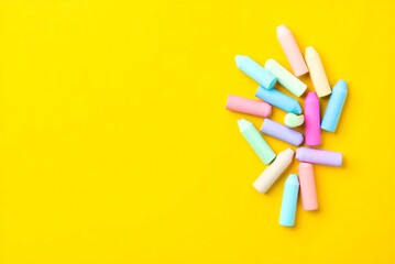 Colorful chalks on yellow background for drawing and art  education and creativity tools