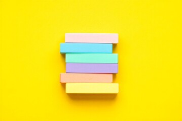 Colorful stack of six pastel sticky notes on bright yellow background for organization and planning  office supplies