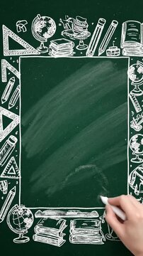 Hand Erasing a Green Chalkboard with School Doodles Frame.