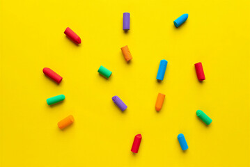 Colorful wax crayons scattered on yellow background for art and drawing  various hues and vibrant colors  creative materials