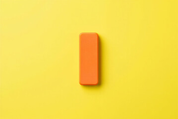 Orange rubber eraser on yellow background used for removing pencil marks and correcting mistakes  simple office supply item