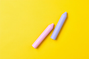 Two colorful lip balms on a bright yellow background for skincare and cosmetics advertising  lip balms in pink and purple hues