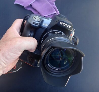 Hand holding Sony alpha 550 DSLR camera