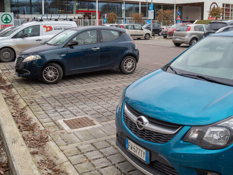 Opel Karl and Lancia Ypsilon cars parked on a paving stone lot outside a Eurospar supermarket