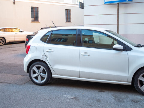 Volkswagen Polo white hatchback showing car crash damage, dent and scratch on rear door and fender, needing auto repair