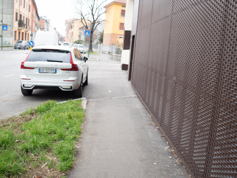 Volvo XC60 B4 mild hybrid SUV parked on an urban sidewalk next to a modern building facade texture