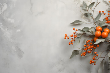 Autumn branch with orange berries on grey marble background. Fall season flat lay composition with copy space for text