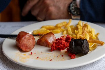 Mixed plate with Spanish homemade pork sausages egg and fries