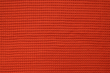 Terracotta waffle fabric texture. Natural cotton textile for a blanket, bath or kitchen towel, bathrobe, bedspread, or bed linen close-up. Abstract fabric background