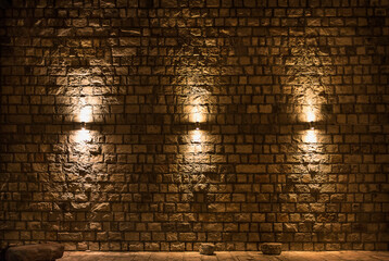 Background old stone wall close-up with three lamps