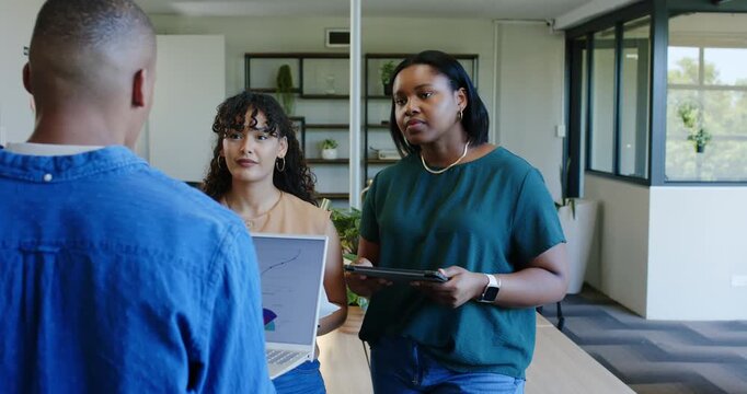 Diverse female coworkers presenting laptop chart clarifying data at long table with man approaching