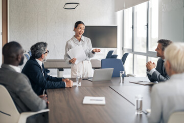 Obraz premium Asian businesswoman leading diverse team meeting in office