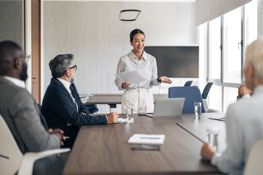 Businesswoman presenting ideas to diverse colleagues in meeting room
