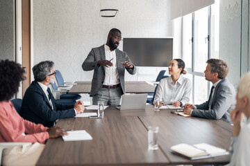 Black businessman leading a diverse team meeting in boardroom
