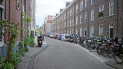 Obraz premium European street view with blurred urban setting, showcasing parked bicycles, brick buildings, and narrow roads, capturing the outdoor essence of a bustling city atmosphere.