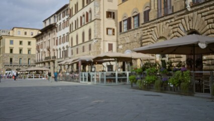 Historic stone plaza with soft defocused bokeh showing blurred cafe terraces and rusticated facades, outdoor plaza; background backdrop copyspace calm.