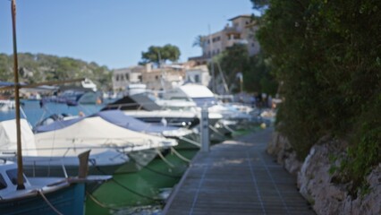 Fototapeta premium Blurred view of boats docked at a picturesque port in cala figuera, mallorca, with bokeh effect enhancing the serene atmosphere.