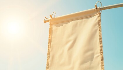 Blank canvas banner hanging against a bright blue sky  