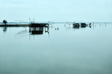 Fototapeta premium Comacchio Valleys, Ferrara, Italy - Views of huts and fishing boats in the Romagna lagoon