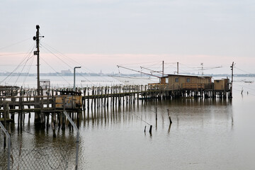 Fototapeta premium Comacchio Valleys, Ferrara, Italy - Views of huts and fishing boats in the Romagna lagoon