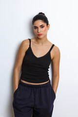 Model poses against a plain background wearing casual attire in a studio setting