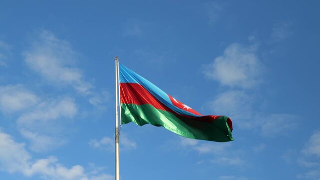 Azerbaijan flag waving in the blue sky. Azerbaijani national flag