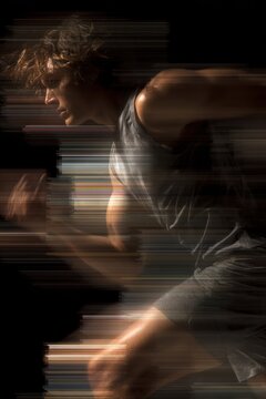 Athlete pushing against strong artificial wind, clothing and hair in motion, resistance and mental strength symbolism. Abstract layers