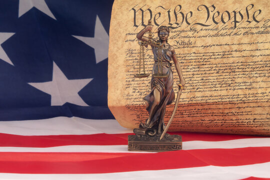 Statue of Justice with American Flag and United States Constitution