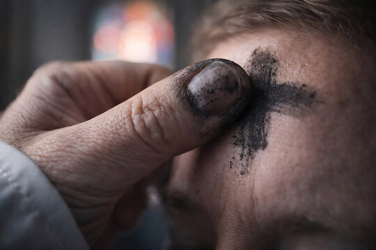Close-up of a thumb applying an ash cross on a forehead for Ash Wednesday, Lenten ritual, UGC style