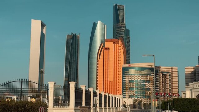 Stunning view of the modern skyline in Abu Dhabi, UAE, featuring iconic Etihad Towers and skyscrapers standing tall under a clear blue sky during a sunny day.

