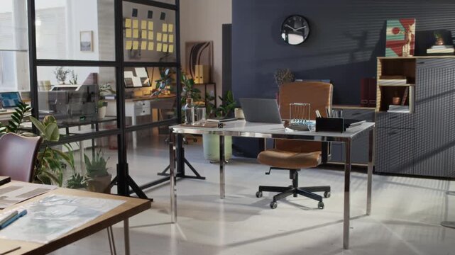 No people low angle shot of modern design bureau office with glass divider, desk with laptop and documents