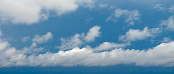 Obraz premium Bright Cumulus Clouds Floating in Blue Sky Background