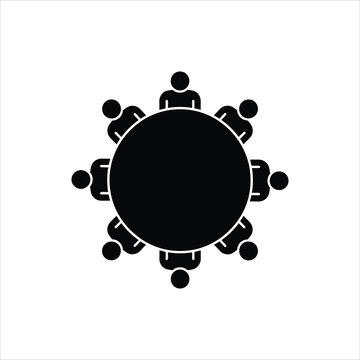 A simple black and white icon depicting people seated around a round table