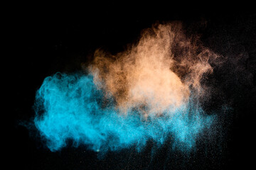 Blue and orange powder exploding on black background