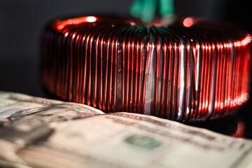 Industrial copper wire coil placed near US dollar bills, symbolizing the link between technology,...