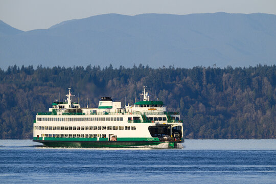 Edmonds, WA, USA - November 30, 2025; Washington State car ferry MV Spokane sailing against wooded hillside