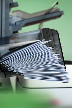 An enveloping machine at the lettershop prepares and processes letters and mailings for the post office or print shop. Print sorted with spine. Lettershop or bookbinder manufacture.