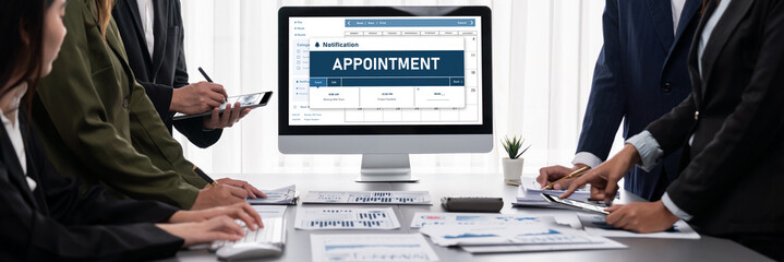 Panorama shot analyst team utilizing BI Fintech to analyze financial report with laptop. Businesspeople analyzing BI data dashboard displayed on laptop screen for business insight. Prodigy