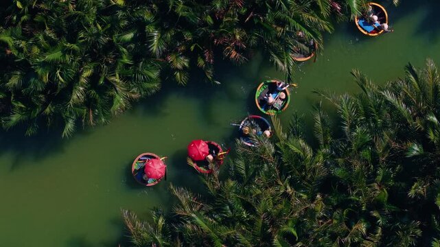 Adventure in Vietnam, Aerial view tourists in Traditional bamboo basket boats on thu bon river with coconut tree in Hoi An.