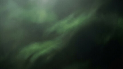 Blurry green abstract background with dark tones and soft lighting effects