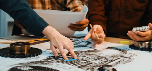 Fototapeta premium A group of engineers collaborates on technical drawings, analyzing components and specifications. They focus on creativity and precision in a collaborative workspace. SACTR