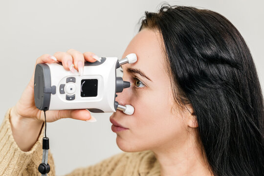 Portable handheld tonometer for glaucoma testing, close-up of the device near a woman&rsquo;s eye during examination. Concept ophthalmology, eye exam, diagnostics